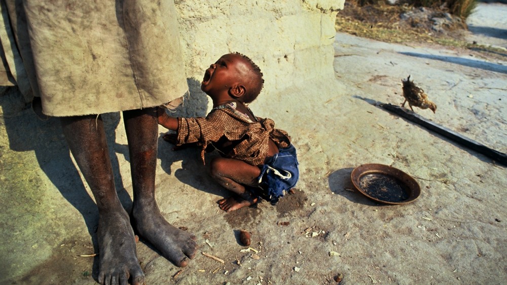 A sick child cries to be picked up during the civil war in Quito, Angola. No matter how many times I photographed scenes of poverty and desperation like this one, I never failed to be confronted by the pathos of it.